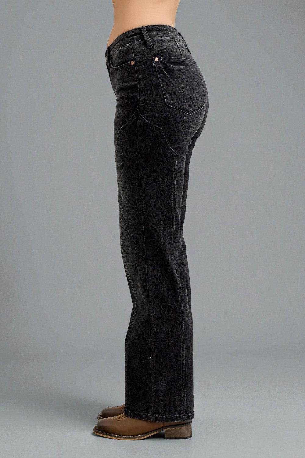 Black jeans worn by a person on a gray background