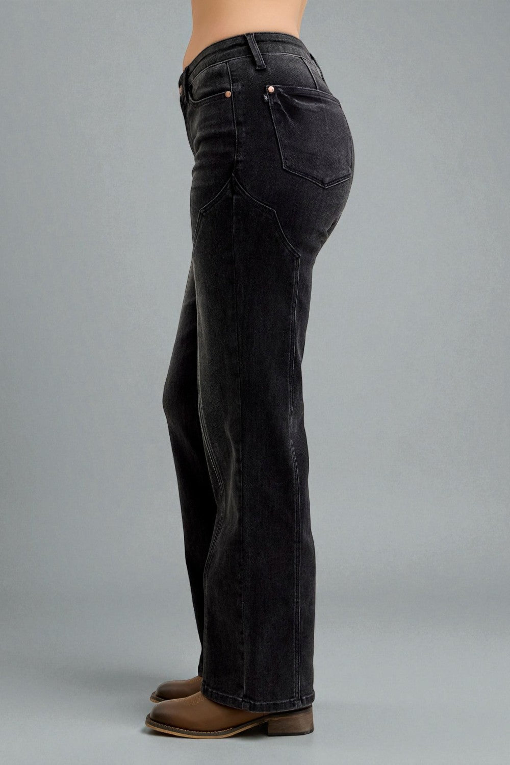 Black jeans worn by a person on a gray background
