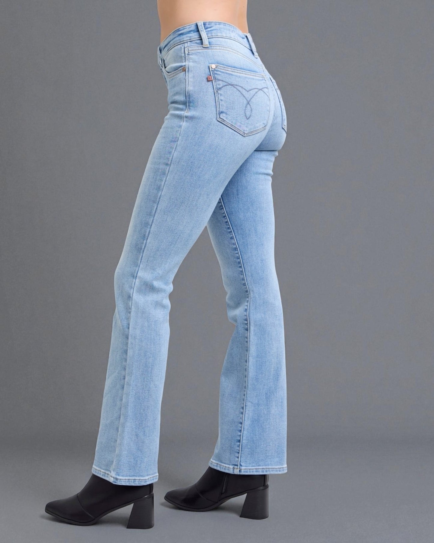 Light blue jeans worn by a person on a gray background