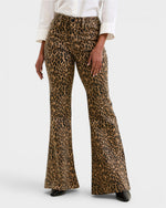 Leopard print flared pants worn by a person on a white background