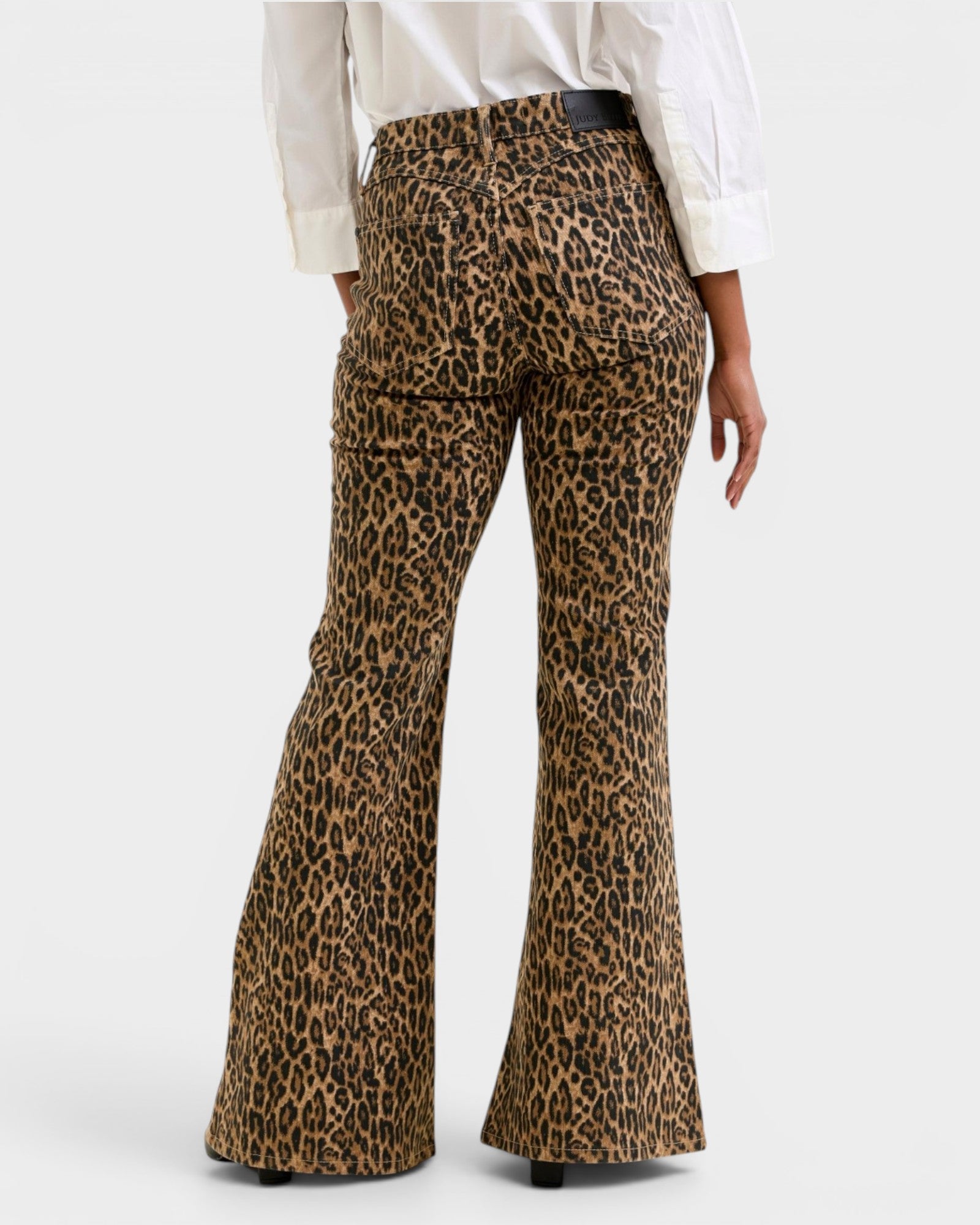 Leopard print flared pants worn by a person on a white background
