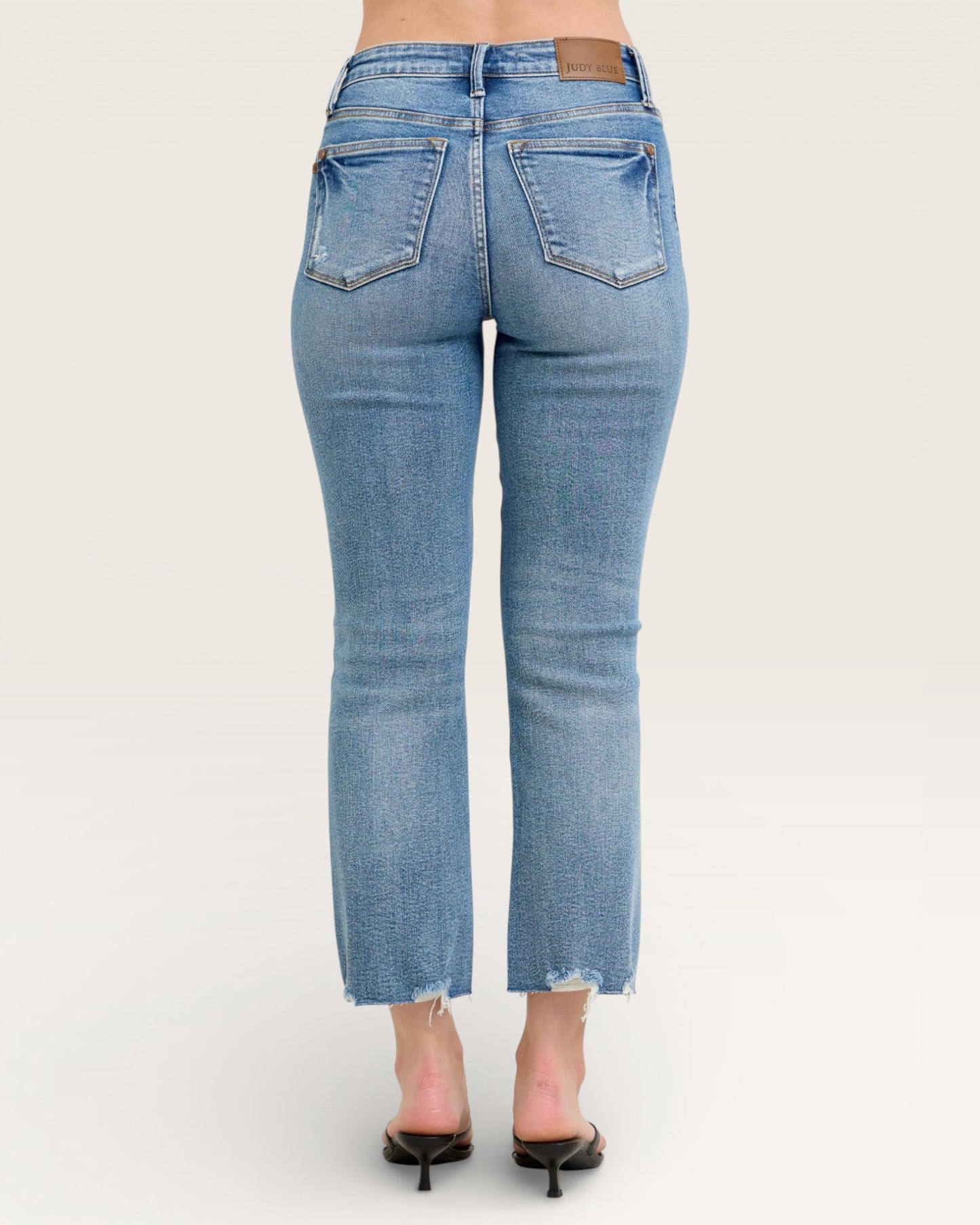Blue jeans worn by a person on a white background