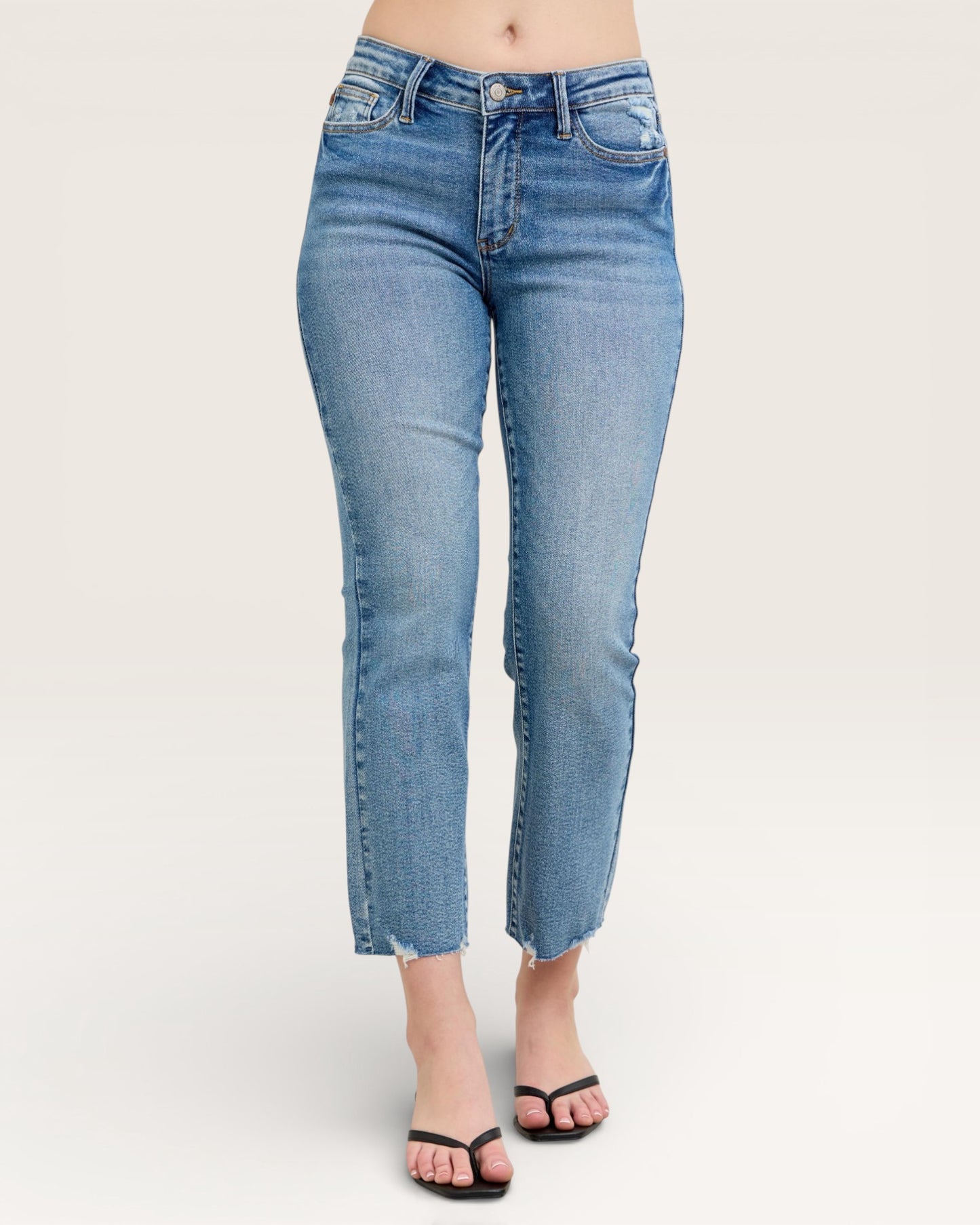 Blue jeans worn by a person on a white background