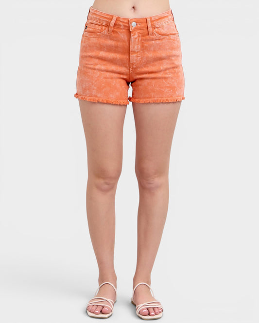 Person wearing orange denim shorts on a white background