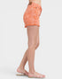 Person wearing orange denim shorts on a white background