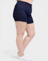 Person wearing dark blue denim shorts on a white background