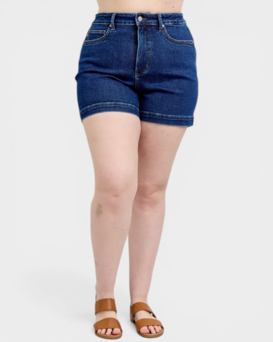 Person wearing blue denim shorts on a white background