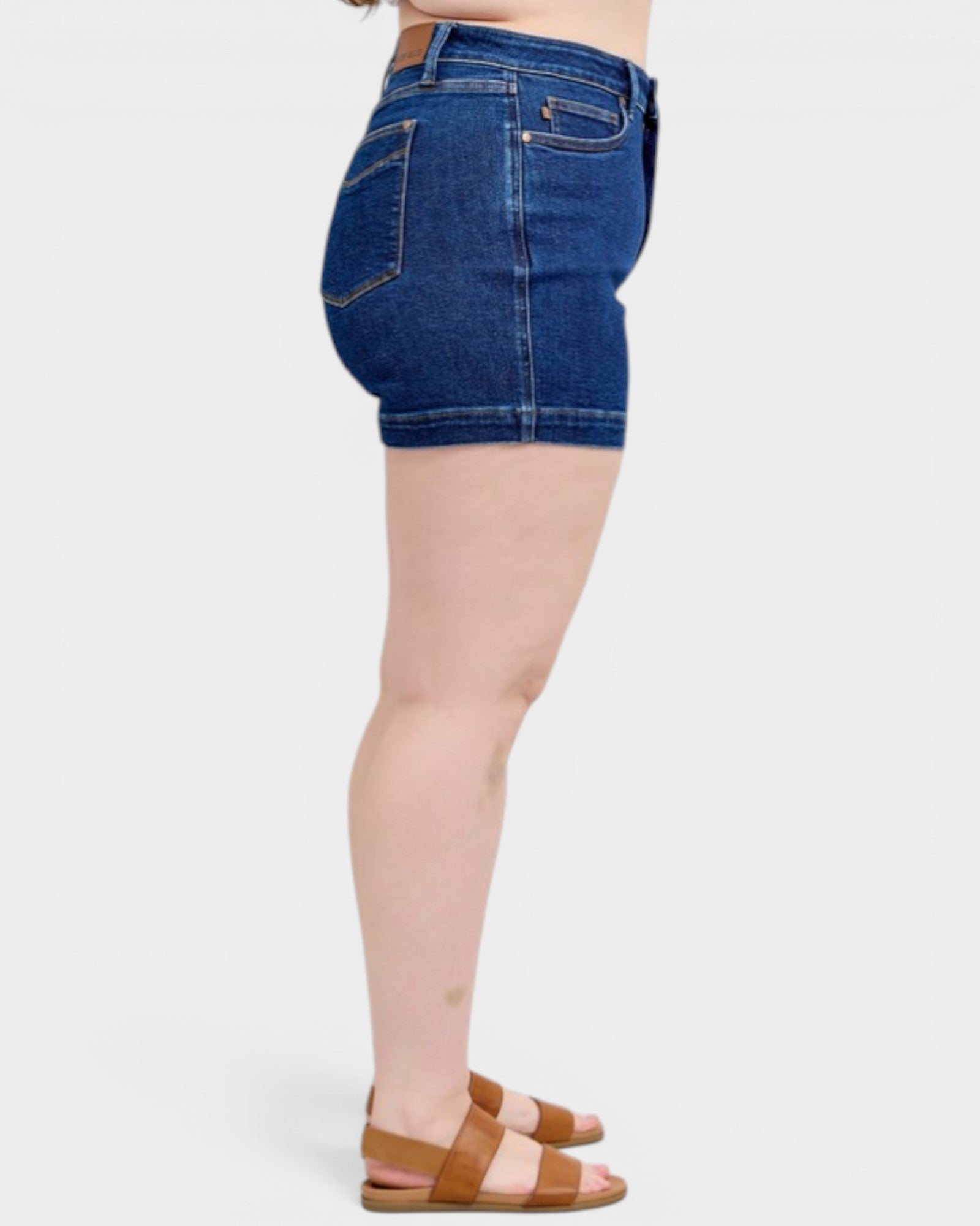 Denim shorts worn by a person on a white background