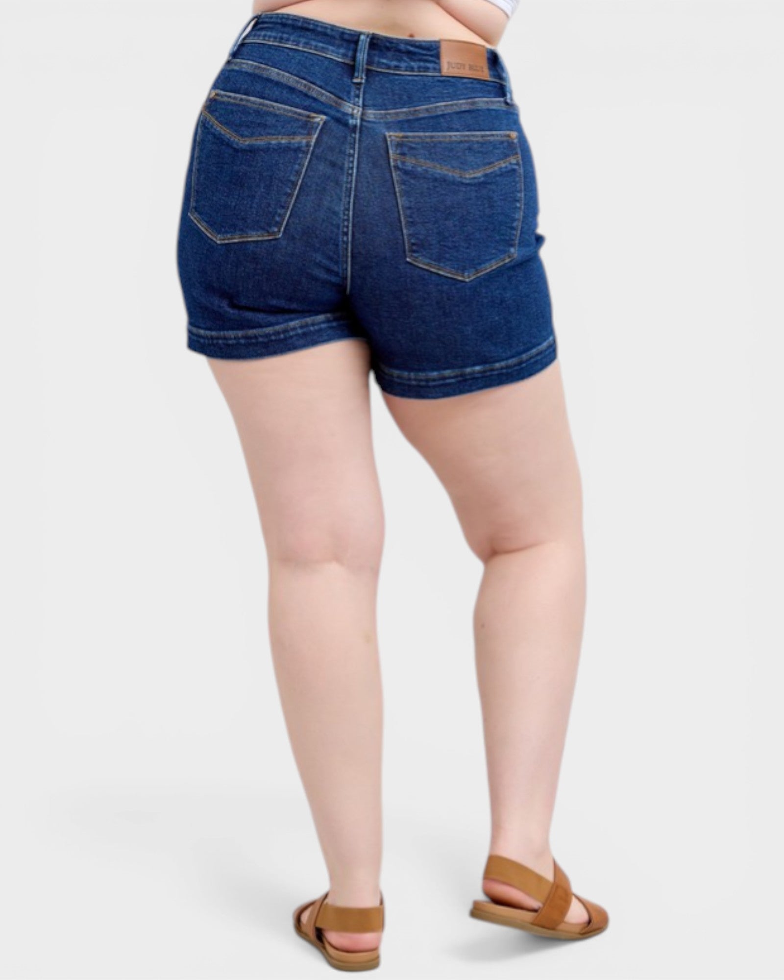 Person wearing blue denim shorts on a white background