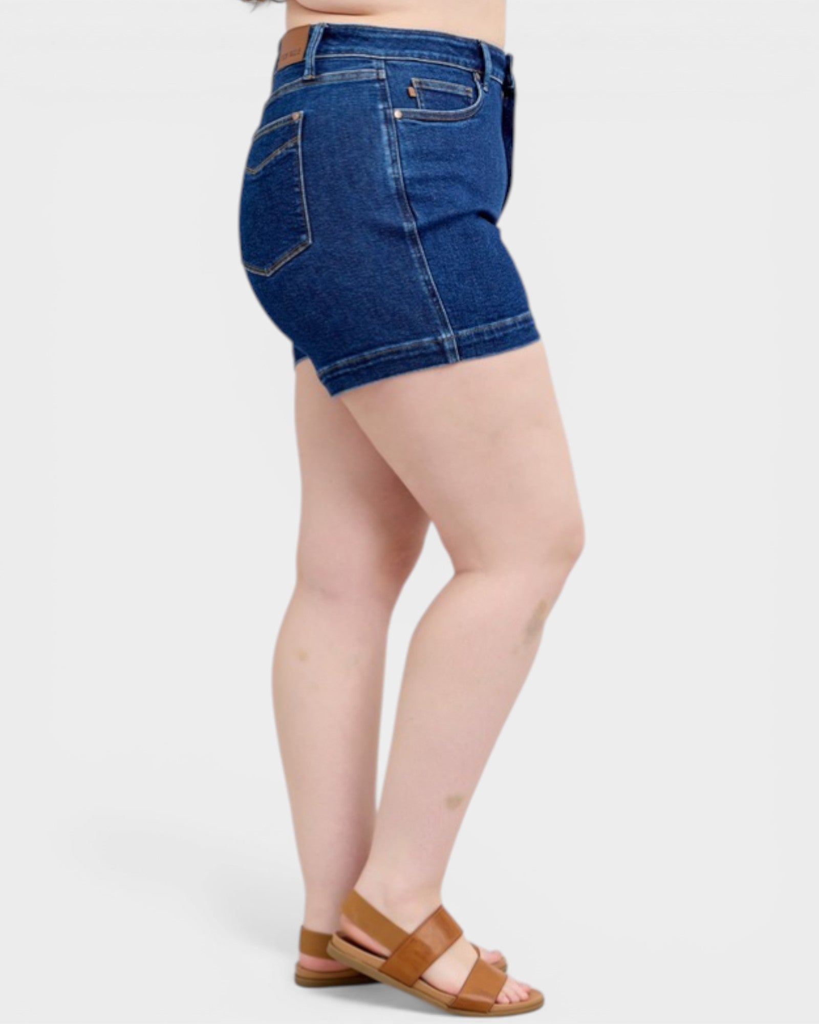 Person wearing blue denim shorts on a white background