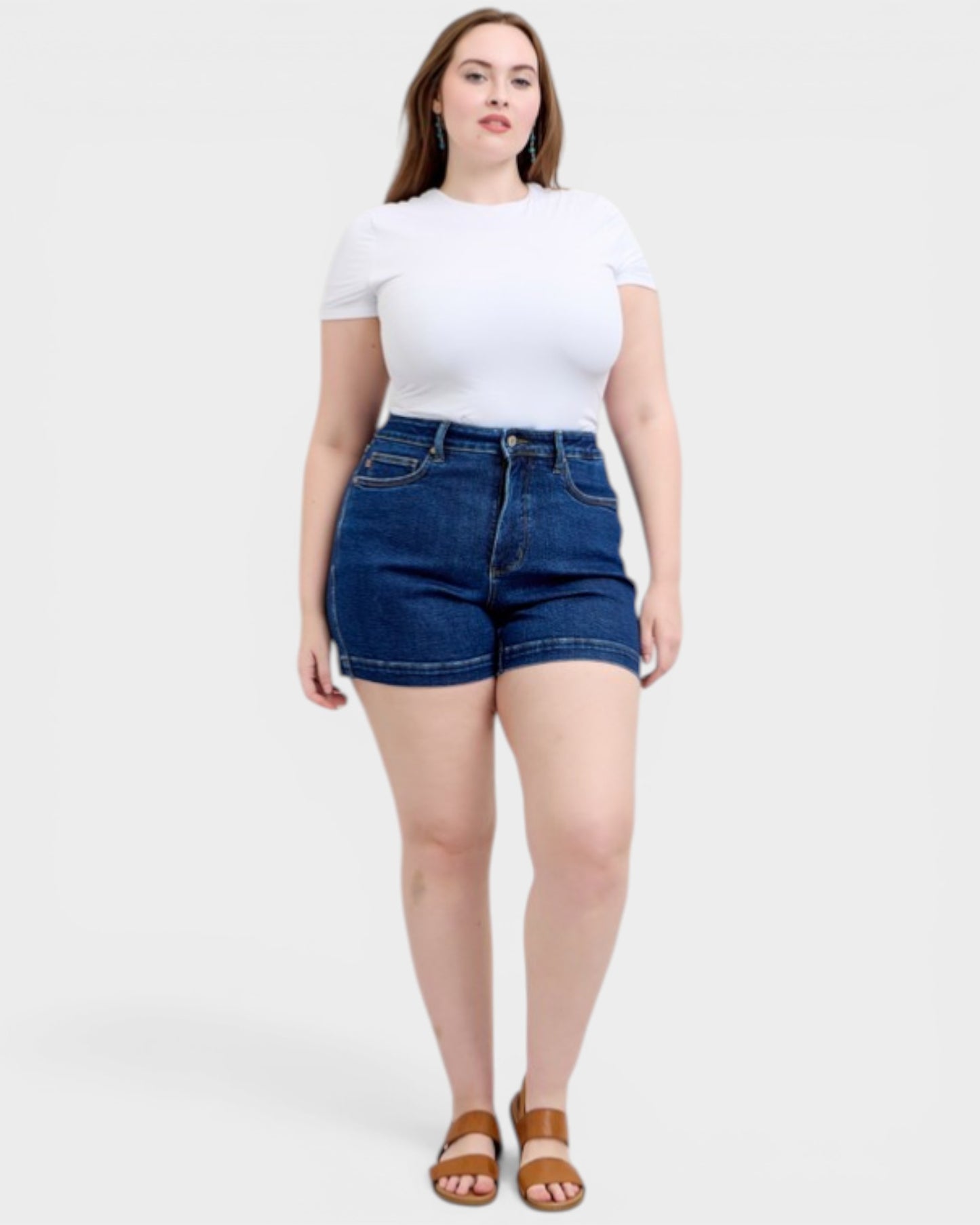Woman wearing a white t-shirt and blue denim shorts on a white background