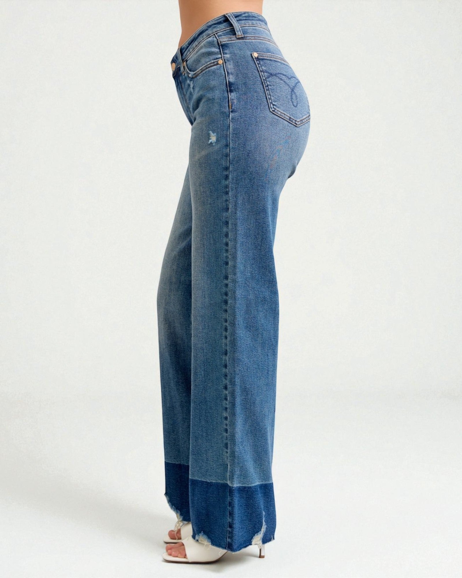 Blue jeans worn by a person on a white background