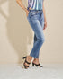 Person wearing blue jeans and a striped top on a beige background