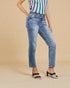 Person wearing blue jeans and a striped top on a beige background