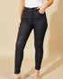 Person wearing black jeans on a beige background