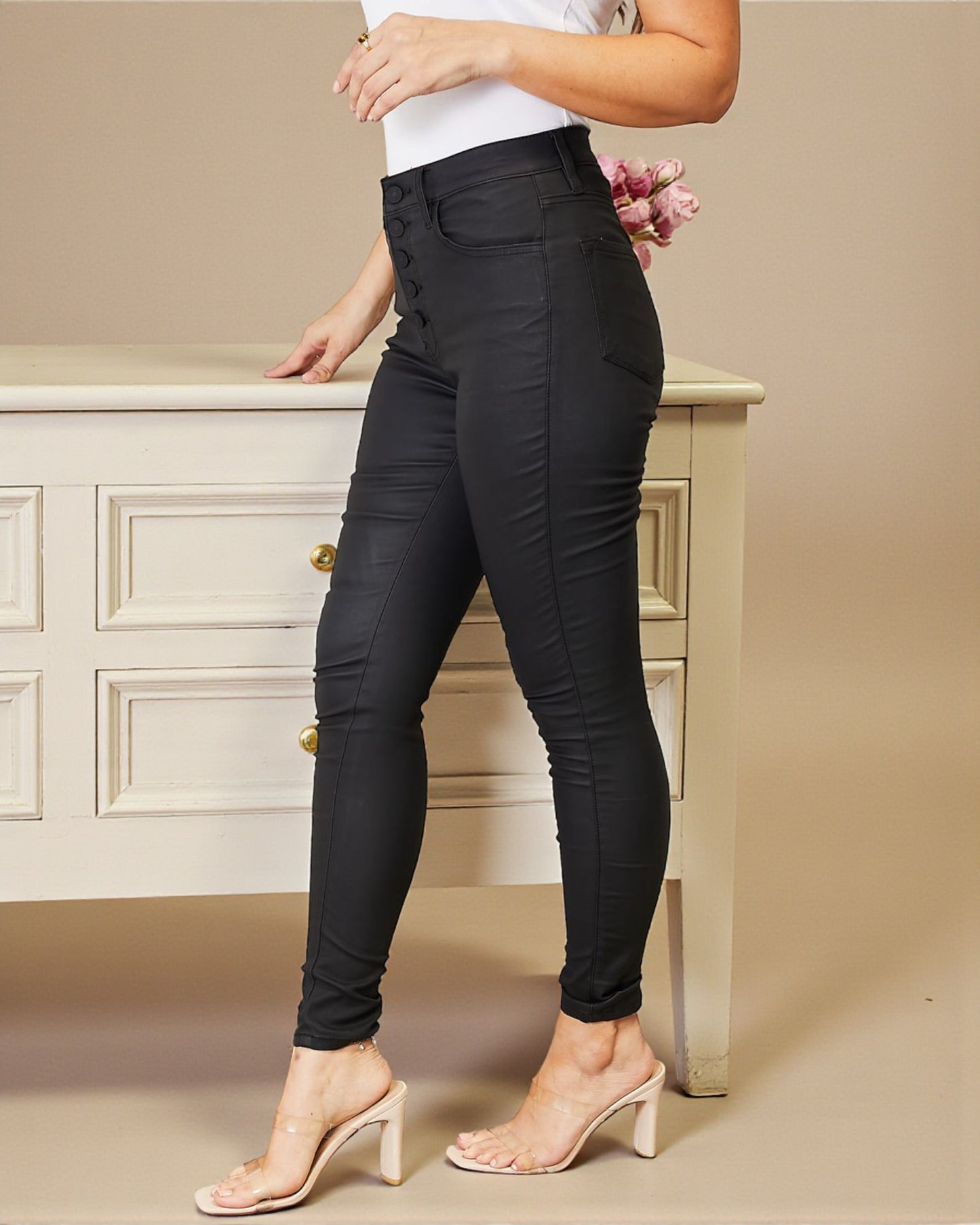 Person wearing black pants standing in front of a beige cabinet.