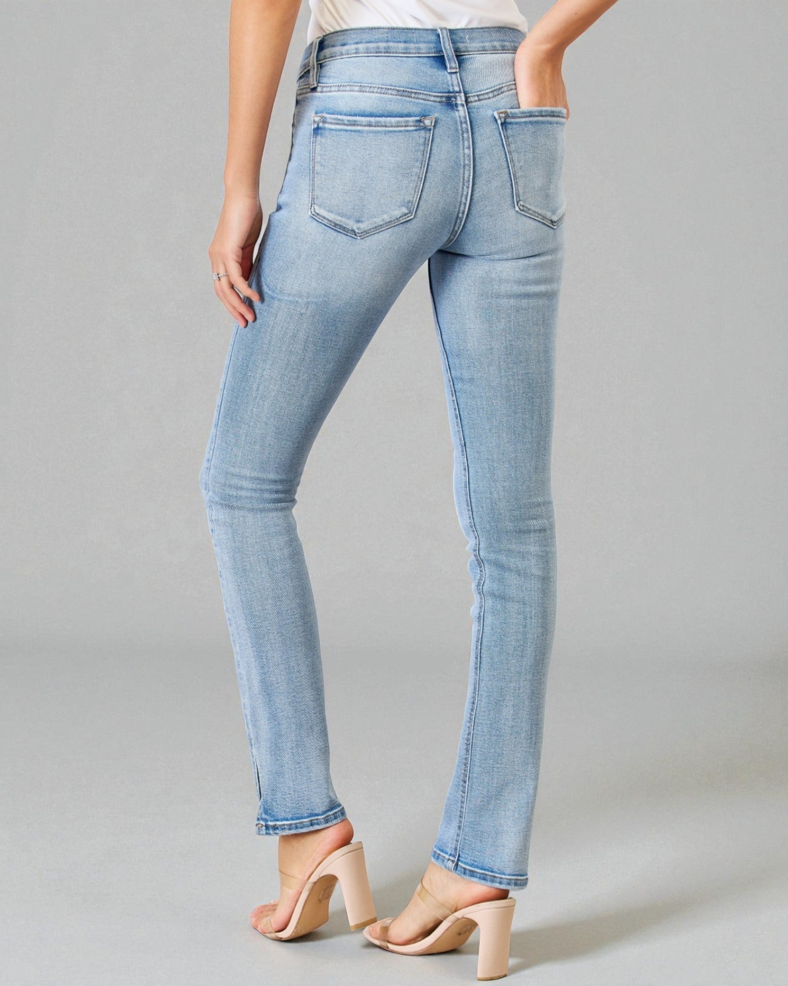 Light blue jeans worn by a person on a gray background