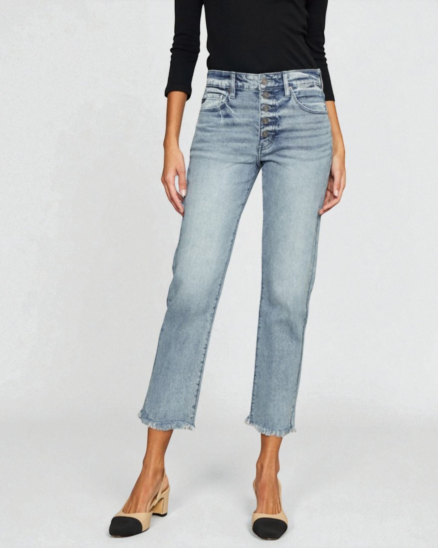 Person wearing light blue jeans on a plain background