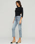Woman wearing a black top and light blue jeans on a white background