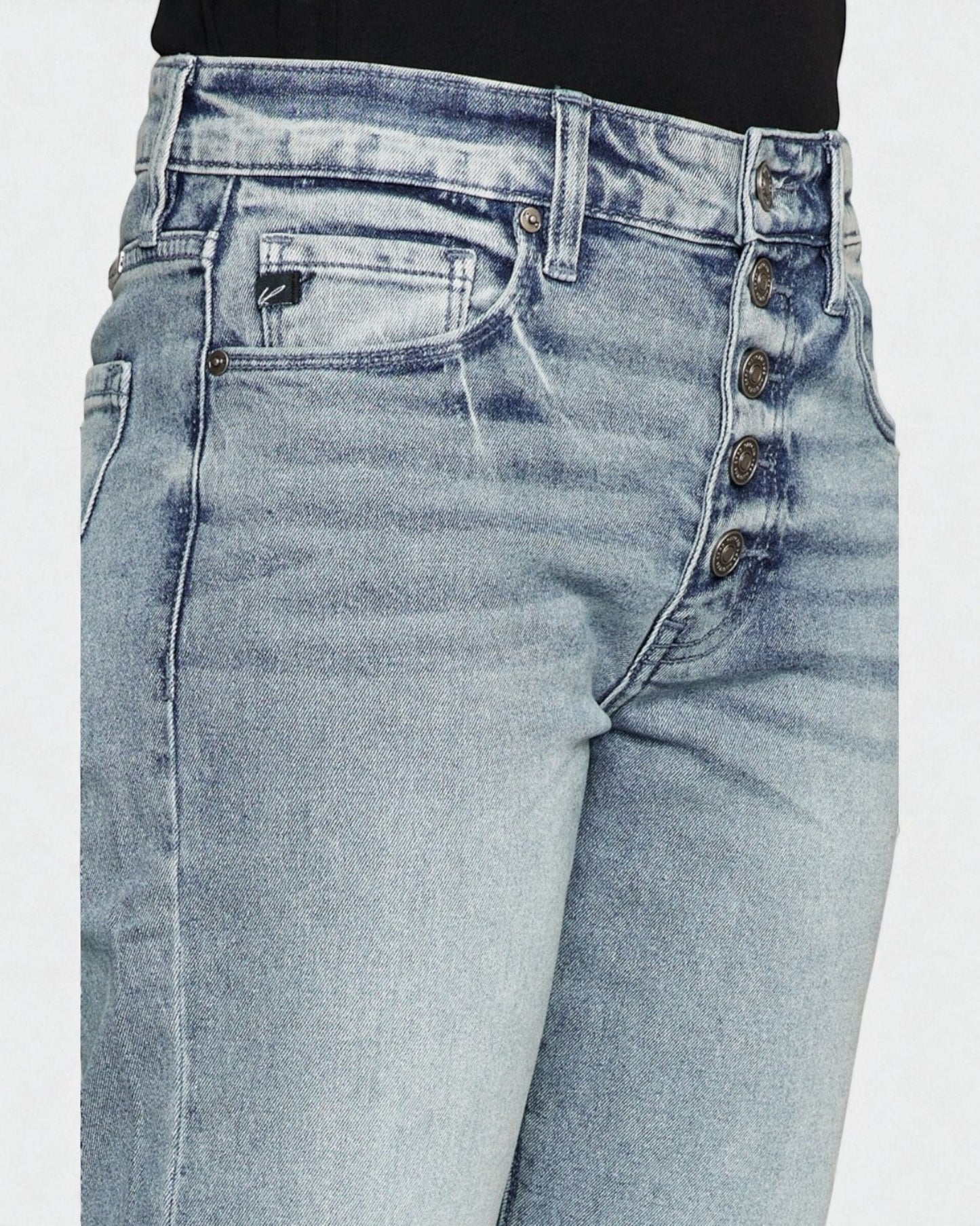 Light blue jeans with button details on a white background