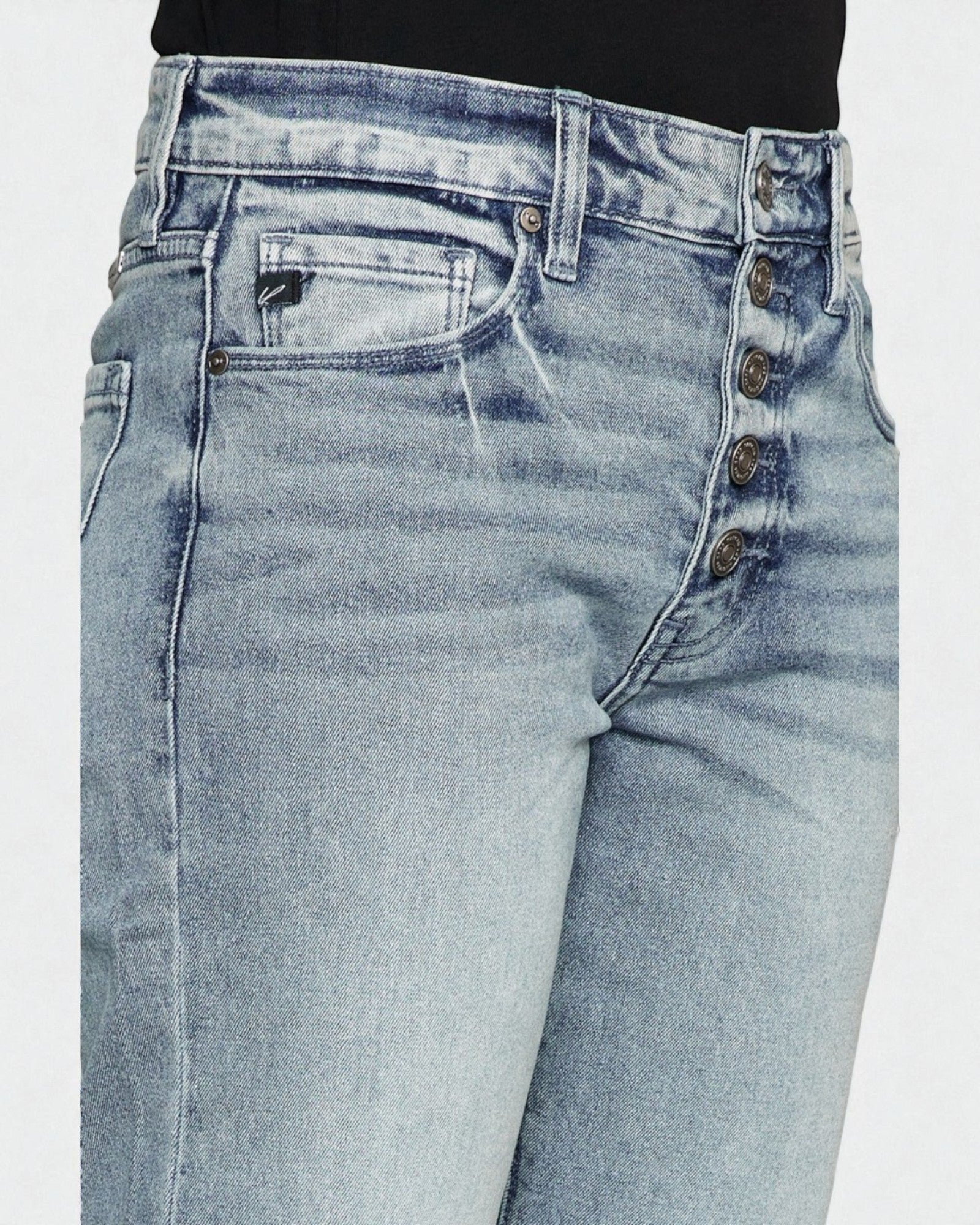 Light blue jeans with button details on a white background