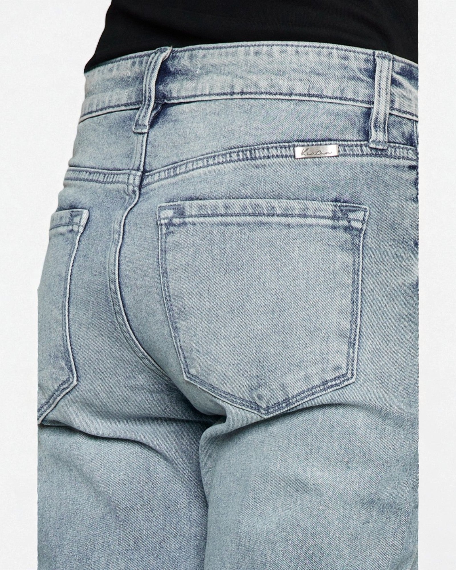 Light blue jeans with a brand label on the back pocket against a light gray background
