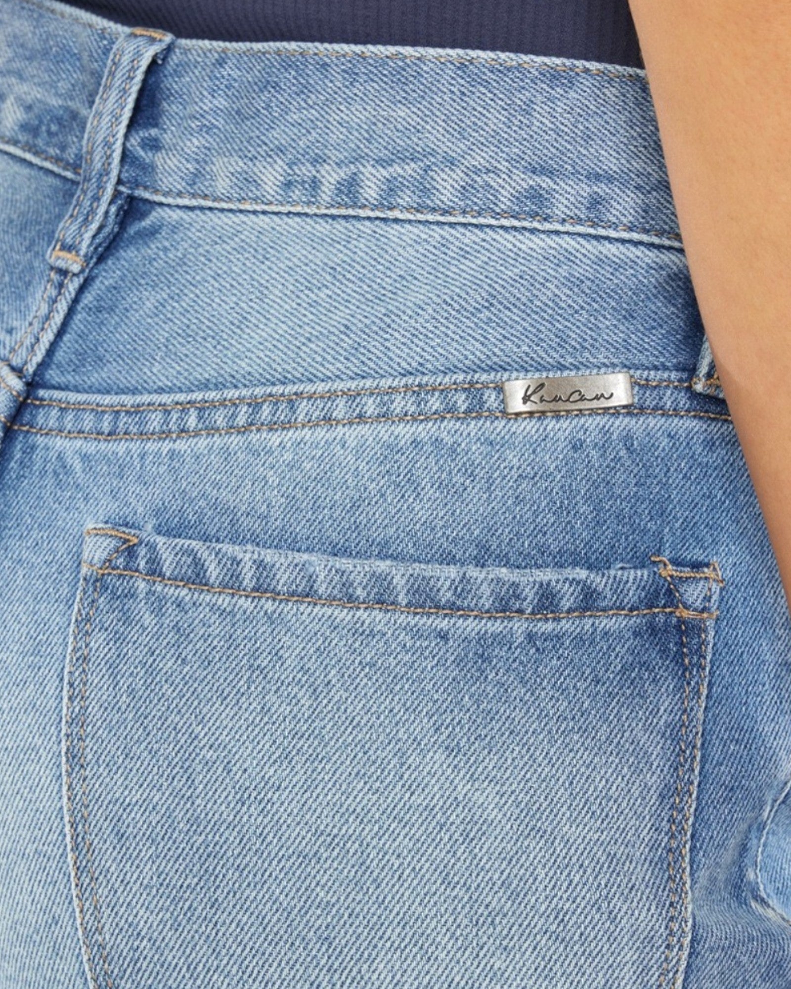 Close-up of blue jeans with a brand label on the pocket.