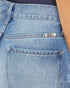 Close-up of blue jeans with a brand label on the pocket.