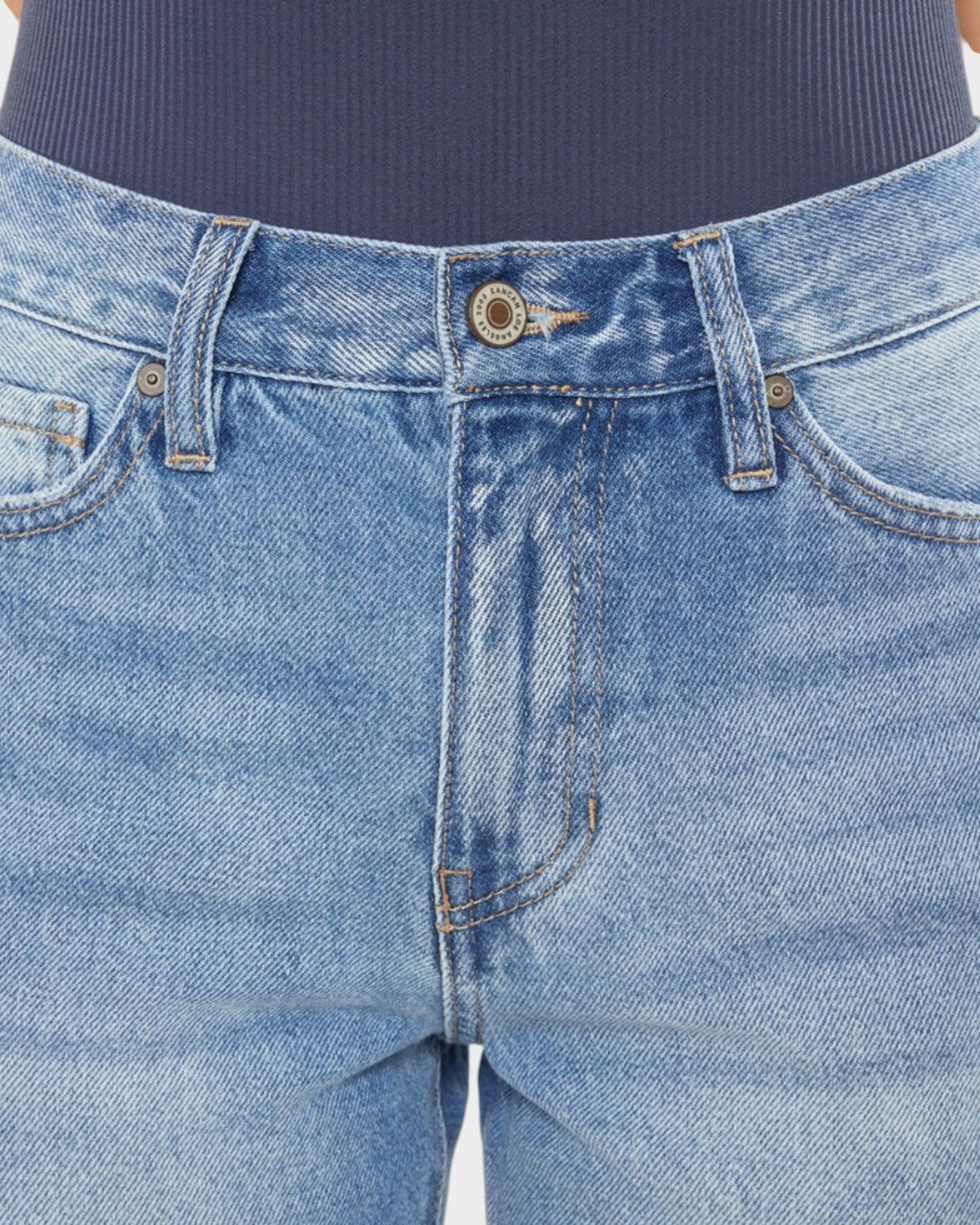 Close-up of blue jeans with a focus on the waistband and stitching.