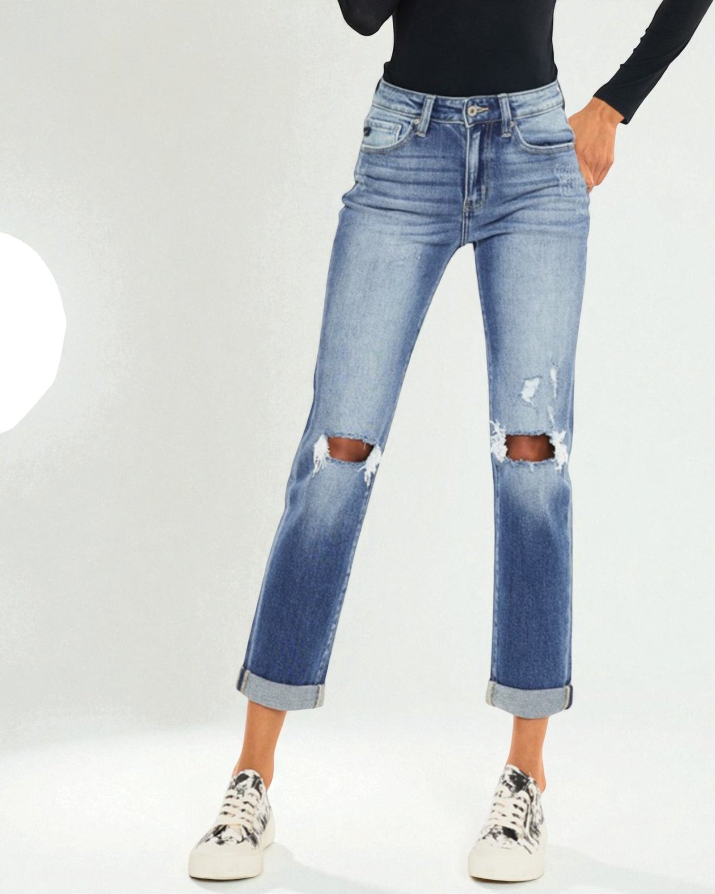 Person wearing distressed blue jeans on a white background