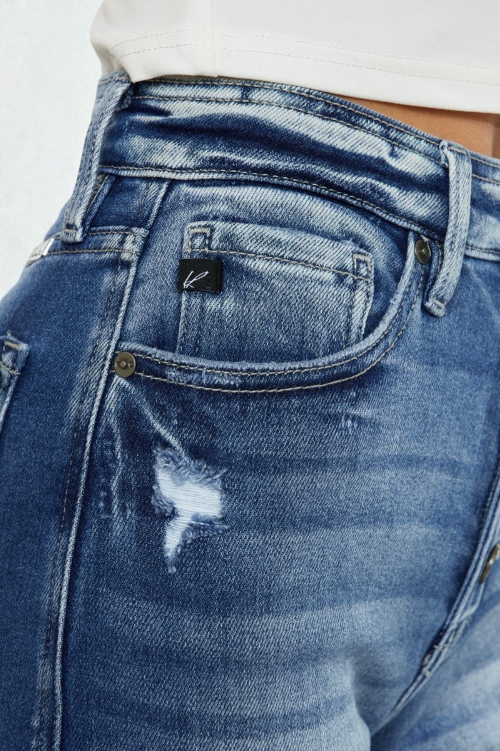 Close-up of blue jeans with a brand logo on the pocket.