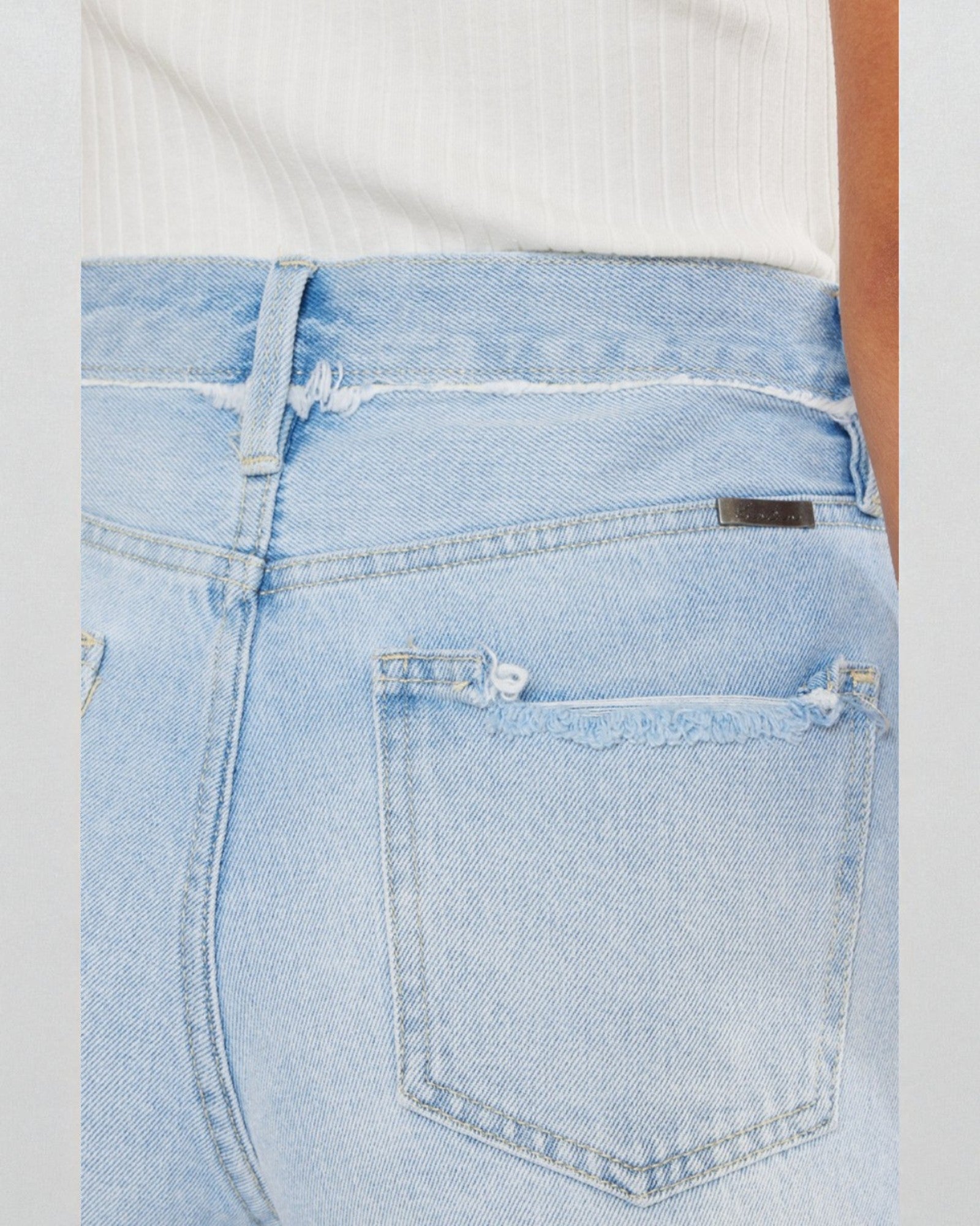 Light blue denim jeans with a brand label on a plain background