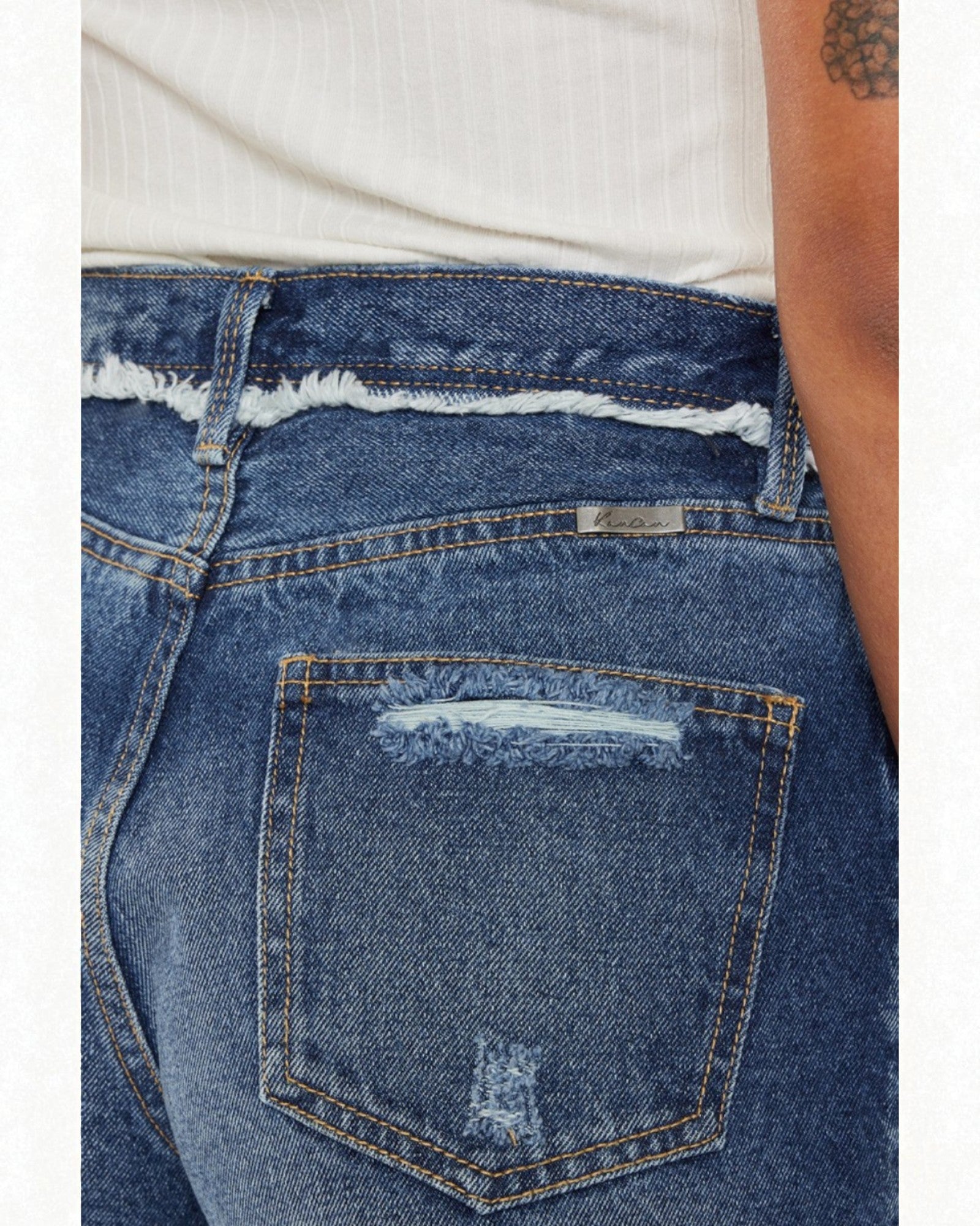 Close-up of blue jeans with a white shirt underneath