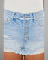 Close-up of light blue denim shorts with button details on a neutral background