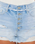 Close-up of light blue distressed denim shorts with a button-front closure, frayed hems, and ripped details, shown on a model.