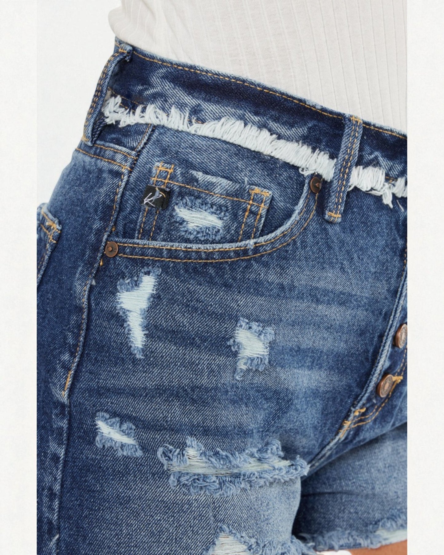 Pantalones cortos de mezclilla con botones y lavado oscuro desgastado