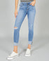 Person wearing light blue distressed jeans on a gray background