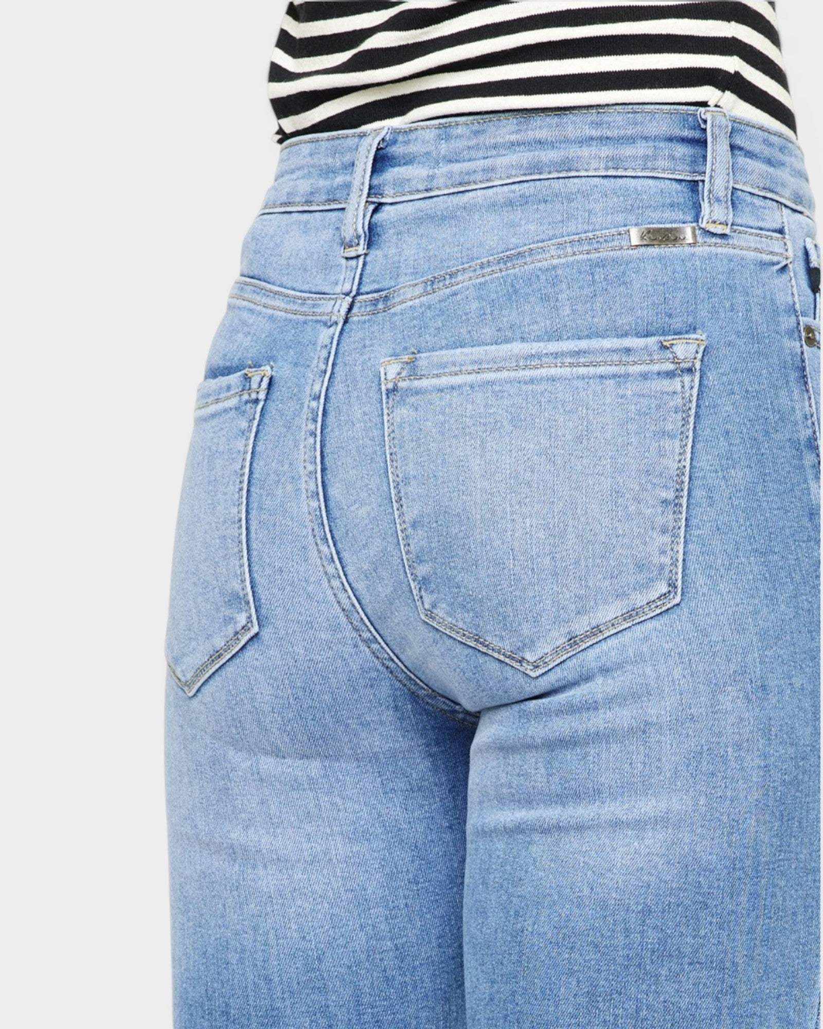 Light blue jeans worn by a person on a white background