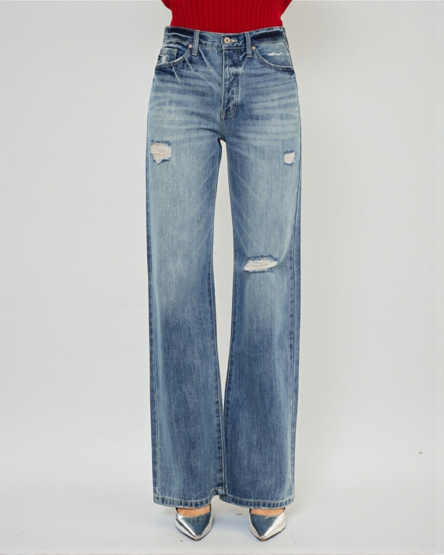 Blue jeans with slight distressing on a white background