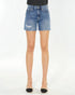 Denim shorts worn by a person on a white background