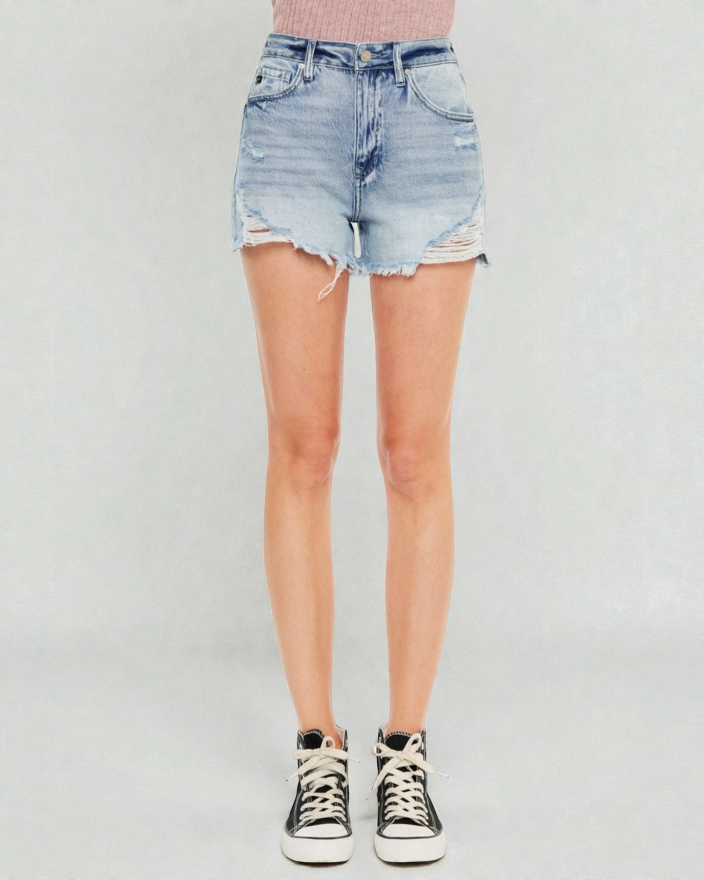 Person wearing a light blue denim skirt on a plain background