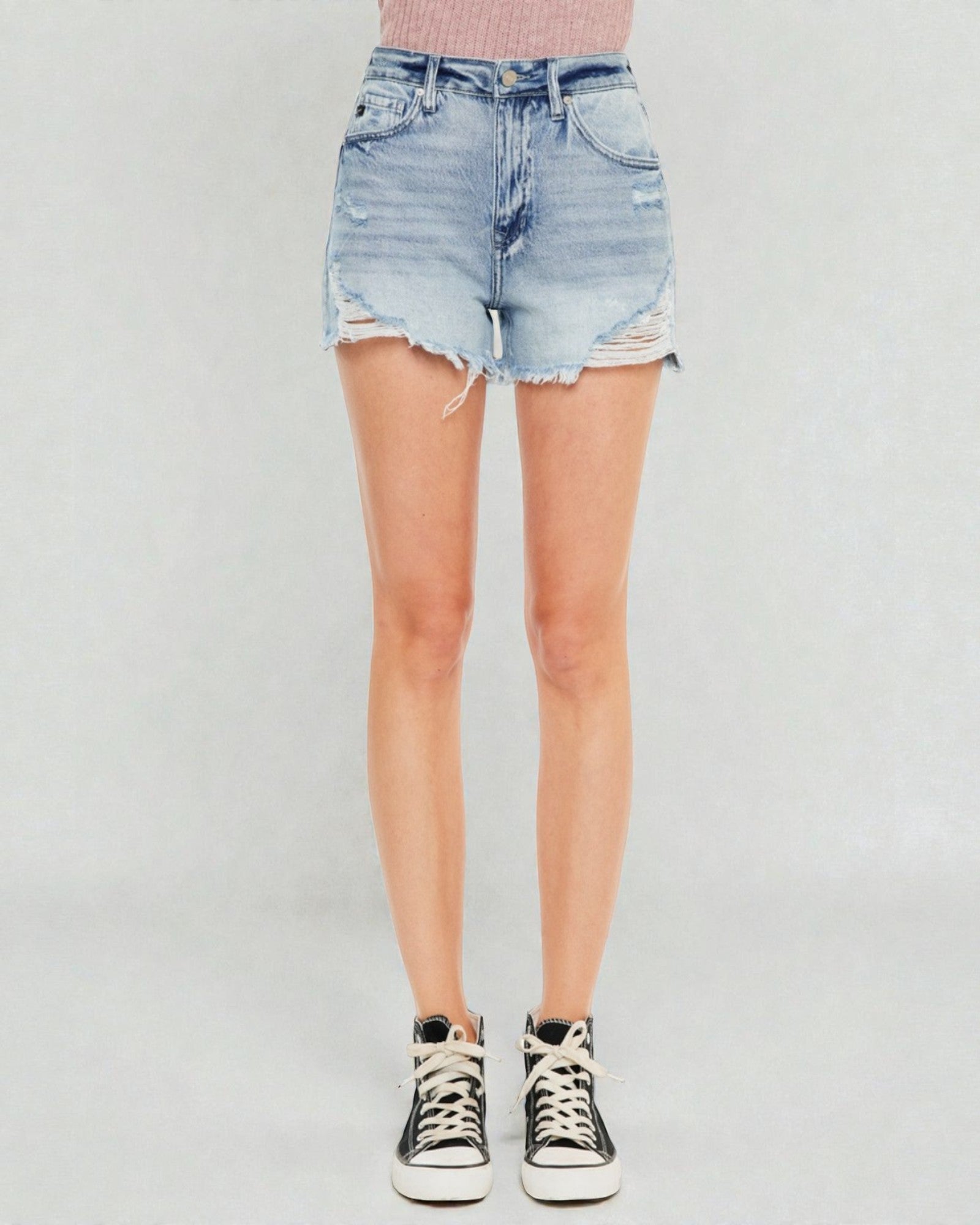 Person wearing a light blue denim skirt on a plain background