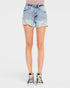 Light wash blue denim shorts with a distressed, frayed hem, shown on a model from the waist down wearing black and white high-top sneakers against a light gray background.