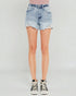 Person wearing a light blue denim skirt on a plain background