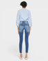 Person wearing blue jeans and a light blue checkered shirt on a white background
