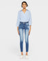 Woman wearing a light blue striped shirt and jeans on a white background