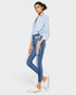 Woman wearing a light blue shirt and jeans on a white background