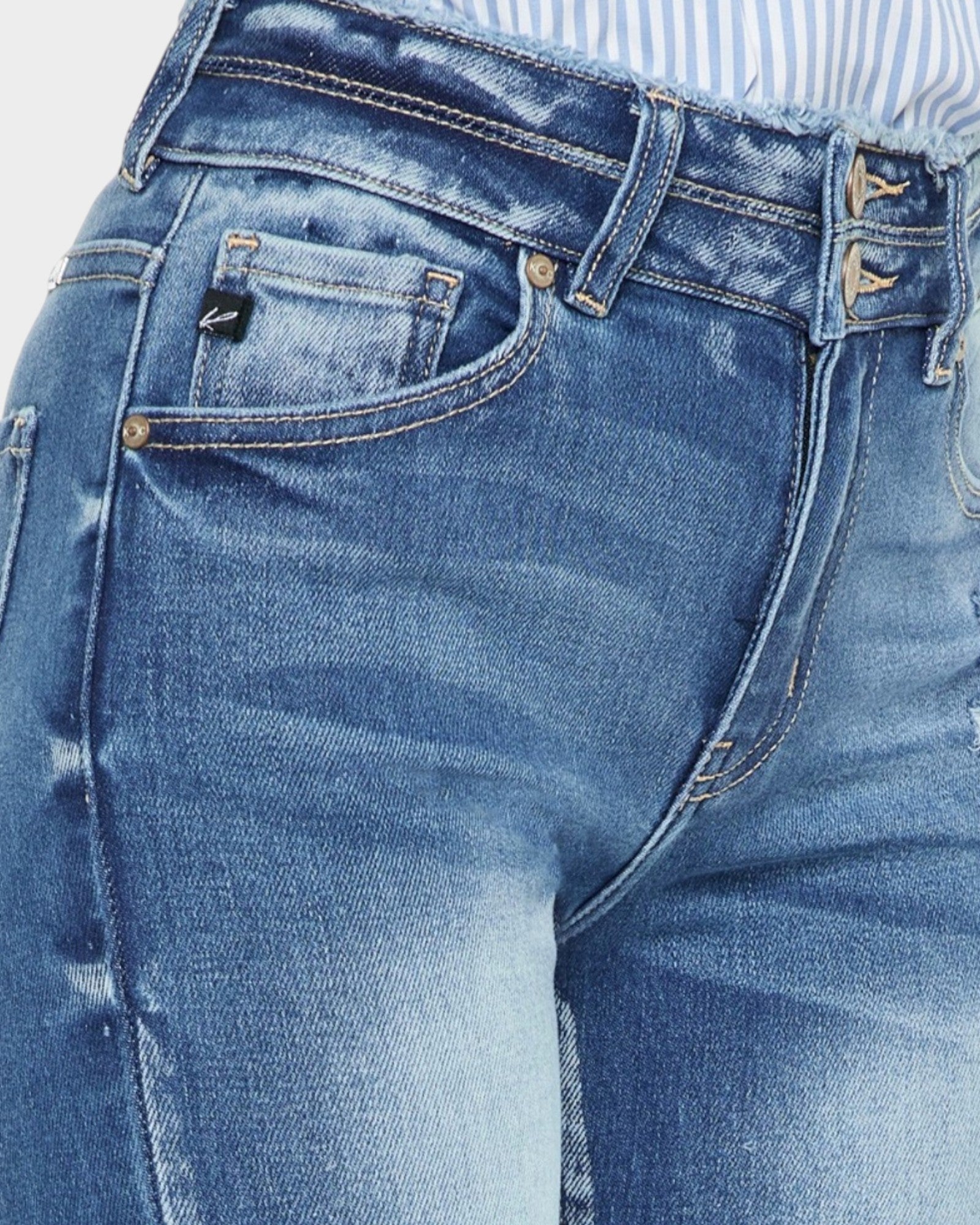 Close-up of blue jeans with brand logo on pocket area