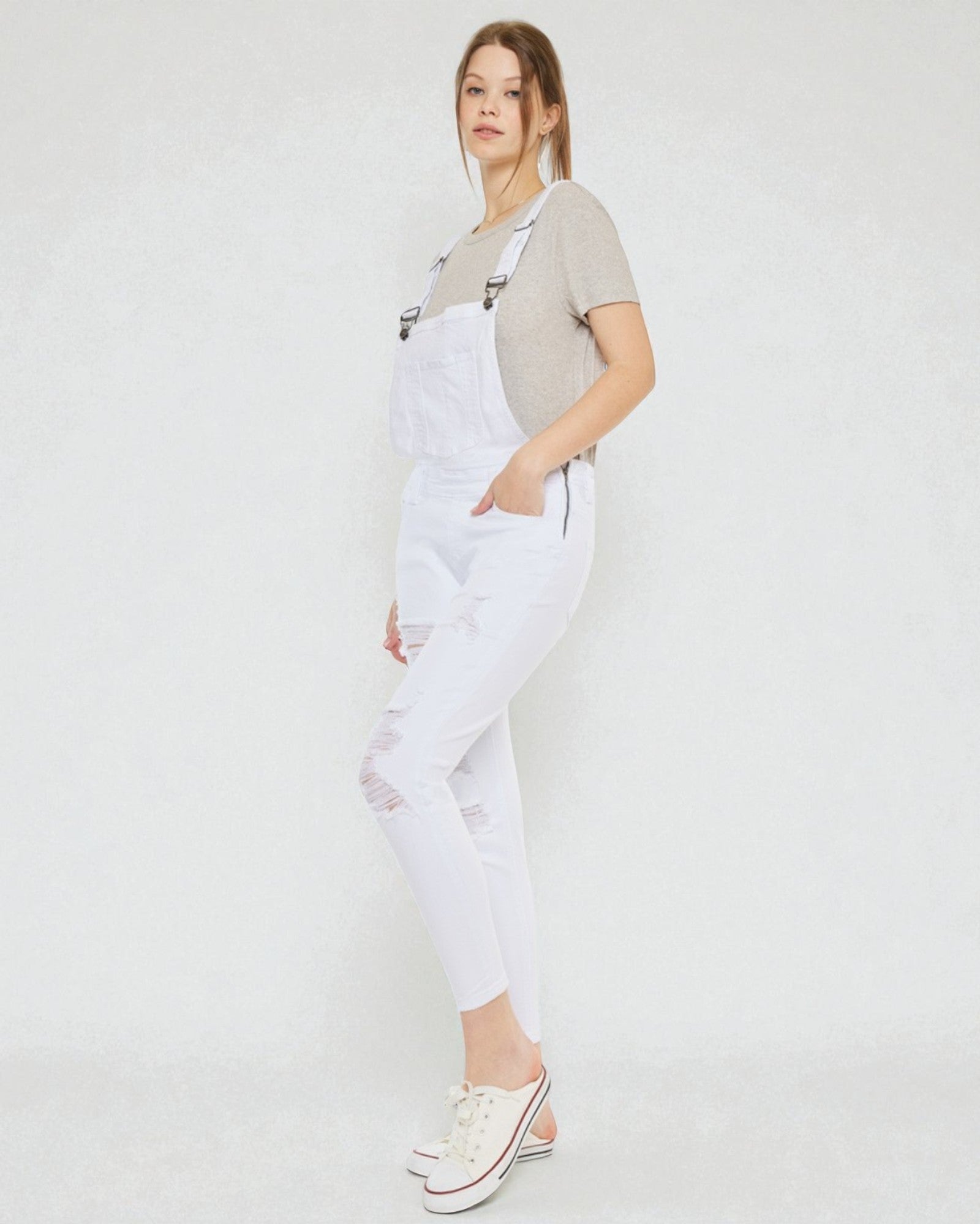 Person wearing white overalls on a plain background