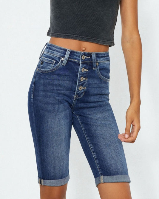 Denim shorts with button details on a plain background